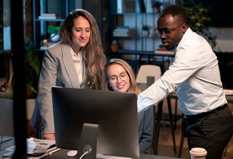 Colleagues reviewing information together at a monitor