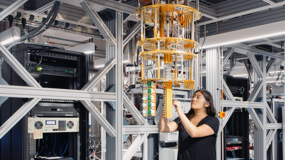 A researcher working on quantum hardware inside a large dilution refrigerator rig in a lab